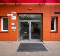 INVESTIČNÉ BÝVANIE V TOP LOKALITE: 2-IZBOVÝ BYT, JÉGÉHO UL, BRATISLAVA - Vchod do budovy na Jégého ulici v Bratislave - Ružinove, s červenými obkladmi.