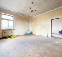 Rodinný dom (bytovka) s pozemkom 554m2, Bobotská Lehota - Izba v rodinnom dome s podlahou s dreveným dekorom a jednoduchým osvetlením.