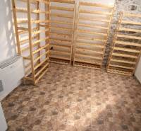 Prenájom gastro priestoru v centre Krupiny - Regály z dreva, kamenná stena, podlaha s geometrickým vzorom v gastro priestoroch.