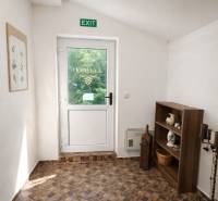 Prenájom gastro priestoru v centre Krupiny - Interiér gastro priestorov s presklenými dvermi, policou a podlahou s dreveným dekorom.