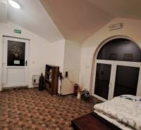 Prenájom gastro priestoru v centre Krupiny - Interiér Gastro priestorov s podlahou s dreveným dekorom, dverami a dekoráciami.