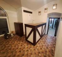 Prenájom gastro priestoru v centre Krupiny - Interiér gastro priestoru s pultom, podlahou s dreveným dekorom a vešiakom.