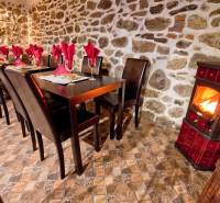 Prenájom gastro priestoru v centre Krupiny - Rustikálne gastro priestory s krbom, kamennou stenou a stolmi so servítkami.