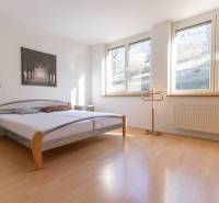 Priestranný 3-izbový byt s loggiou, Staré Mesto - Svetlá spálňa s posteľou a podlahou s dreveným dekorom v 3-izbovom byte.