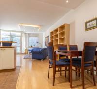 Priestranný 3-izbový byt s loggiou, Staré Mesto - Obývacia izba s podlahou s dreveným dekorom, jedálenským stolom a práčkou v 3-izbovom byte.