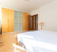 Priestranný 3-izbový byt s loggiou, Staré Mesto - Svetlá spálňa v 3-izbovom byte s podlahou s dreveným dekorom a priestrannou skriňou.