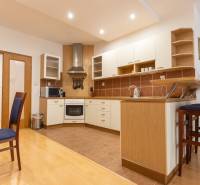 Priestranný 3-izbový byt s loggiou, Staré Mesto - Kuchyňa v 3-izbovom byte s podlahou s dreveným dekorom a barovým pultom.