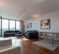 Moderný 2-izbový byt s balkónom, Eurovea - Obývačka s veľkými oknami, podlaha s dreveným dekorom, pohodlný nábytok a jedálenský kút.