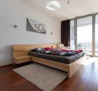 Moderný 2-izbový byt s balkónom, Eurovea - Spálňa v 2-izbovom byte s podlahou s dreveným dekorom a priestrannými oknami.