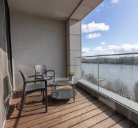 Moderný 2-izbový byt s balkónom, Eurovea - Balkón v 2-izbovom byte s výhľadom na rieku, podlaha s dreveným dekorom.