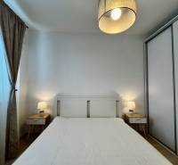 PRENÁJOM NOVOSTAVBA 2 izb.byt, BALKÓN, PARKOVACIE MIESTO, BIELY KOSTOL - Spálňa v 2-izbovom byte s bielou posteľou, nočnými stolíkmi a lampami.