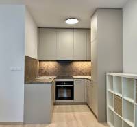 PRENÁJOM NOVOSTAVBA 2 izb.byt, BALKÓN, PARKOVACIE MIESTO, BIELY KOSTOL - Kuchyňa v 2-izbovom byte s podlahou s dreveným dekorom a úložnými policami.