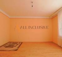 NA PREDAJ 7 IZBOVÝ RODINNÝ DOM, DUNAJSKÁ STREDA - Izba s podlahou s dreveným dekorom, kobercom, záclonou a svetlooranžovými stenami v rodinnom dome.