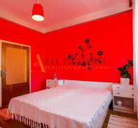 NA PREDAJ 7 IZBOVÝ RODINNÝ DOM, DUNAJSKÁ STREDA - Spálňa v rodinnom dome s červenými stenami, posteľou a dekoráciou na stene.