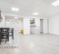 NA PRENÁJOM OBCHODNÝ PRIESTOR-KANCELÁRIA ,DUN. STREDA - Priestranný interiér s bielou stenou na ulici Jilemnického, kancelárie, stôl a sedenie.