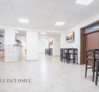 NA PRENÁJOM OBCHODNÝ PRIESTOR-KANCELÁRIA ,DUN. STREDA - Svetlá kancelária na ulici Jilemnického s barovým pultom, obrázkami a dreveným nábytkom.