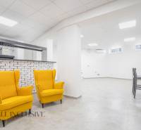 NA PRENÁJOM OBCHODNÝ PRIESTOR-KANCELÁRIA ,DUN. STREDA - Interiér s dvoma žltými kreslami, biely stĺp, barová stena a stolík s dvoma stoličkami.