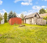 NA PREDAJ 2-IZBOVÝ RODINNÝ DOM S PODKROVÍM, BODÍKY - Záhrada v Bodíkoch s drevenými a murovanými prístreškami pri rodinnom dome na slnečnom dni.