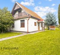 NA PREDAJ 2-IZBOVÝ RODINNÝ DOM S PODKROVÍM, BODÍKY - Rodinný dom v Bodíkoch s trávnatým pozemkom a stromami v pozadí.