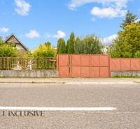 NA PREDAJ 2-IZBOVÝ RODINNÝ DOM S PODKROVÍM, BODÍKY - Rodinný dom v Bodíkoch s bránou, oploteným pozemkom a zeleňou na pozadí.