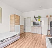 NA PREDAJ VÝNIMOČNÝ RODINNÝ DOM VO VEĽKOM MEDERI - Obývacia izba s rozkladacím gaučom, skriňou a podlahou s dreveným dekorom v rodinnom dome.