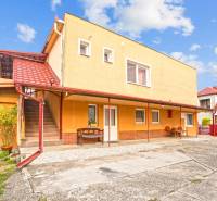 NA PREDAJ VÝNIMOČNÝ RODINNÝ DOM VO VEĽKOM MEDERI - Rodinný dom vo Veľkom Mederi s červenou strechou a vonkajšími schodmi.