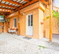 NA PREDAJ VÝNIMOČNÝ RODINNÝ DOM VO VEĽKOM MEDERI - Zastrešená terasa rodinného domu vo Veľkom Mederi s drevenými konštrukciami a posedovou zónou.