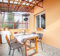 NA PREDAJ VÝNIMOČNÝ RODINNÝ DOM VO VEĽKOM MEDERI - Zastrešená terasa so stolom a stoličkami v rodinnom dome.