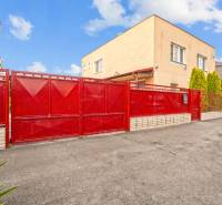 NA PREDAJ VÝNIMOČNÝ RODINNÝ DOM VO VEĽKOM MEDERI - Rodinný dom vo Veľkom Mederi, výrazná červená brána, betónová príjazdová cesta.