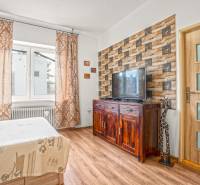 NA PREDAJ VÝNIMOČNÝ RODINNÝ DOM VO VEĽKOM MEDERI - Spálňa v rodinnom dome so stenou s tehlovým obkladom a podlahou s dreveným dekorom.