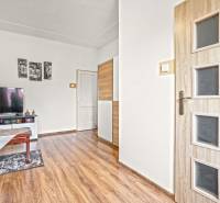 NA PREDAJ VÝNIMOČNÝ RODINNÝ DOM VO VEĽKOM MEDERI - Obývacia izba v rodinnom dome s TV a podlahou s dreveným dekorom.