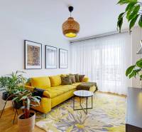 PREDAJ, 3izb. zariadený byt, novostavba Zelená stráň, Košická Nová Ves - Farebný obývací priestor s rastlinami, žltou pohovkou a dekoratívnymi obrazmi, 3-izbový byt.