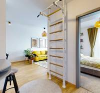 PREDAJ, 3izb. zariadený byt, novostavba Zelená stráň, Košická Nová Ves - Interiér 3-izbového bytu s podlahou s dreveným dekorom, rebrinou a výhľadom do spálne.