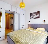 PREDAJ, 3izb. zariadený byt, novostavba Zelená stráň, Košická Nová Ves - Spálňa v 3-izbovom byte s pohodlnou posteľou, vstavanou skriňou a podlahou s dreveným dekorom.