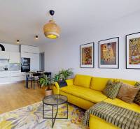 PREDAJ, 3izb. zariadený byt, novostavba Zelená stráň, Košická Nová Ves - Obývacia izba s kuchyňou v 3-izbovom byte, žltá sedačka, podlaha s dreveným dekorom.