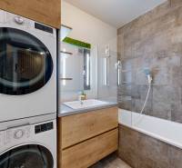 PREDAJ, 3izb. zariadený byt, novostavba Zelená stráň, Košická Nová Ves - Kúpeľňa v 3-izbovom byte s práčkou, sušičkou, vaňou a šedými obkladačkami.