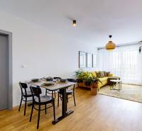 PREDAJ, 3izb. zariadený byt, novostavba Zelená stráň, Košická Nová Ves - Obývačka v 3-izbovom byte s podlahou s dreveným dekorom, žltou sedačkou a jedálenským stolom.