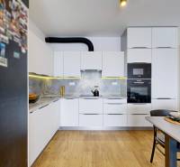 PREDAJ, 3izb. zariadený byt, novostavba Zelená stráň, Košická Nová Ves - Kuchyňa v 3-izbovom byte s bielymi skrinkami a podlahou s dreveným dekorom.