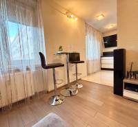 Štýlový, zariadený 2- izbový byt s balkónom pri stanici!!! - Interiér 2-izbového bytu s podlahou s dreveným dekorom, barovými stoličkami a dekoráciami.