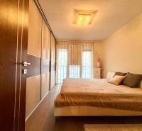 Štýlový, zariadený 2- izbový byt s balkónom pri stanici!!! - Spálňa v 2-izbovom byte s veľkou posteľou a podlahou s dreveným dekorom.