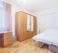 ZNÍŽENÁ CENA | NA PREDAJ DVOJGENERAČNÝ RODINNÝ DOM, AMADE KRAČANY - Svetlá spálňa s dreveným nábytkom, pracovným stolom a veľkou posteľou na ulici Amade Kračany.