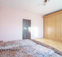 ZNÍŽENÁ CENA | NA PREDAJ DVOJGENERAČNÝ RODINNÝ DOM, AMADE KRAČANY - Spálňa s drevenou skriňou, svetloružovou stenou a dvojitým posteľným poťahom.