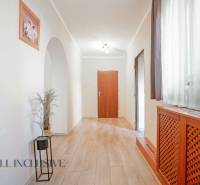 ZNÍŽENÁ CENA | NA PREDAJ DVOJGENERAČNÝ RODINNÝ DOM, AMADE KRAČANY - Chodba s drevenou podlahou a rastlinou, súčasť rodinného domu na ulici Amade Kračany.