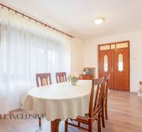 ZNÍŽENÁ CENA | NA PREDAJ DVOJGENERAČNÝ RODINNÝ DOM, AMADE KRAČANY - Jedáleň v rodinnom dome na ulici Amade Kračany s dreveným nábytkom a bielymi závesmi.