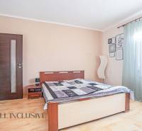 ZNÍŽENÁ CENA | NA PREDAJ DVOJGENERAČNÝ RODINNÝ DOM, AMADE KRAČANY - Spálňa v rodinnom dome s drevenou podlahou, veľkým oknom a svetlými závesmi.