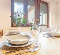 ZNÍŽENÁ CENA | NA PREDAJ DVOJGENERAČNÝ RODINNÝ DOM, AMADE KRAČANY - Jedálenský stôl so stolovaním, pohármi a výhľadom na záhradu v Rodinnom dome.