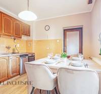 ZNÍŽENÁ CENA | NA PREDAJ DVOJGENERAČNÝ RODINNÝ DOM, AMADE KRAČANY - Kuchyňa s drevenými skrinkami a stolom v rodinnom dome na ulici Amade Kračany.