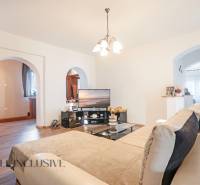 ZNÍŽENÁ CENA | NA PREDAJ DVOJGENERAČNÝ RODINNÝ DOM, AMADE KRAČANY - Obývačka na ulici Amade Kračany v rodinnom dome, pohodlný gauč, televízor, drevená podlaha.