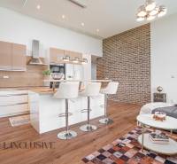 NA PREDAJ NADŠTANDARDNÁ 4-IZB. NOVOSTAVBA, DUN. KLÁTOV - Kuchyňa s ostrovčekom a barovými stoličkami v rodinnom dome, tehlová stena.