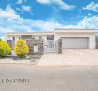 NA PREDAJ NADŠTANDARDNÁ 4-IZB. NOVOSTAVBA, DUN. KLÁTOV - Rodinný dom v Dunajskom Klátove so záhradou a garážou pod modrou oblohou.